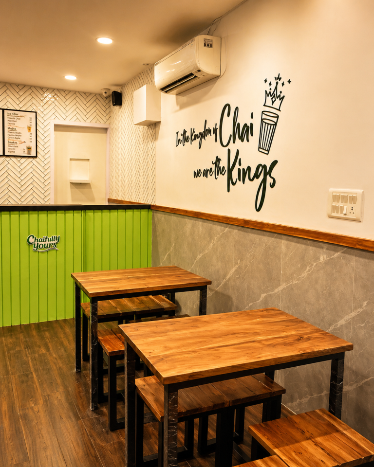 Seating area inside Chai Kings Ameerpet with wooden tables, wall art, and cozy café interiors.