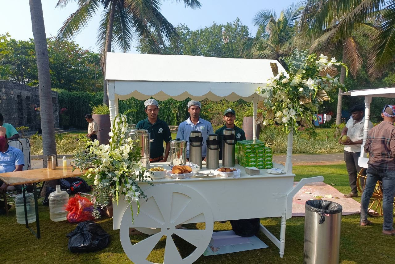 Wedding chai catering cart with tea dispensers, snacks, floral décor and service staff at an outdoor event in Hyderabad.