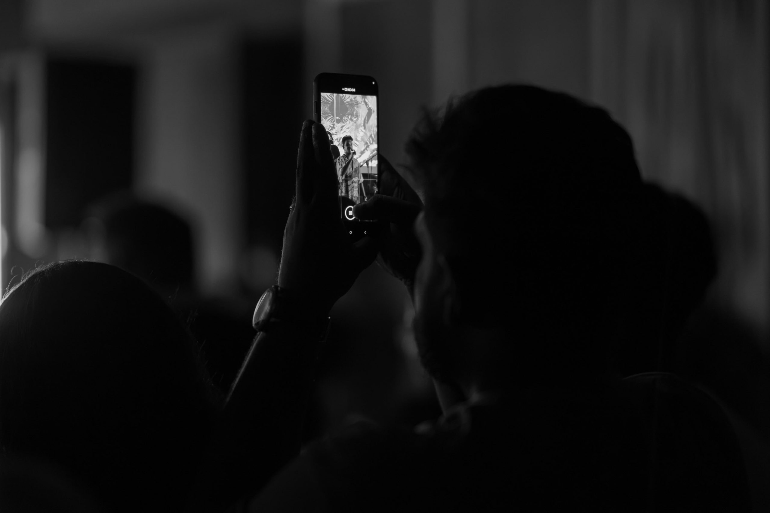 Audience members recording the live music performance on their phones